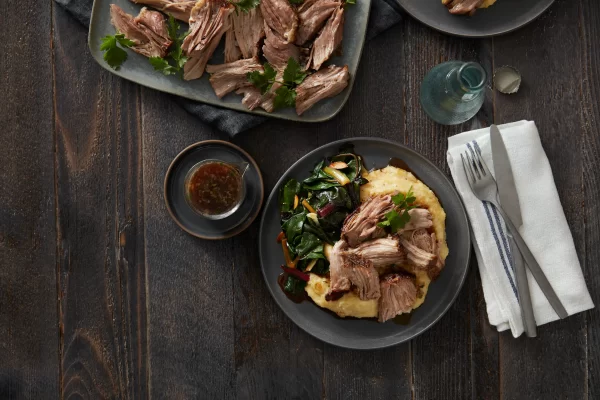 Plated slow-cooked Prairie Fresh® pork served with creamy polenta and sautéed vegetables