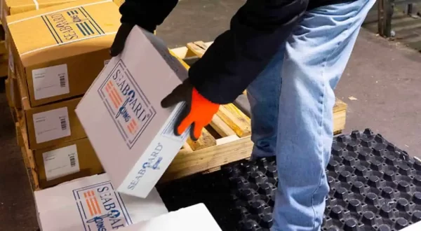 Worker handling Seaboard Foods product boxes in a warehouse