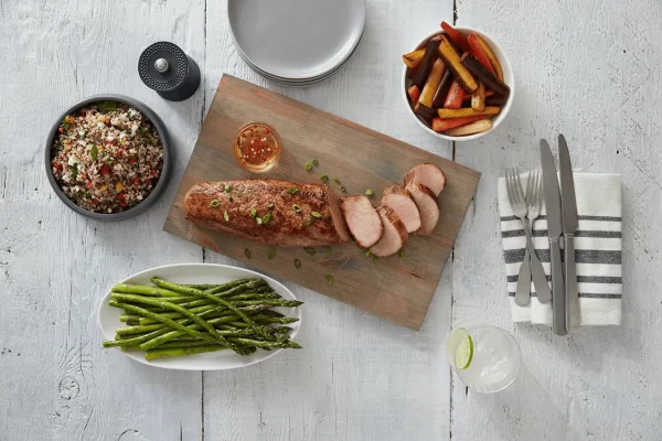 Sliced Prairie Fresh® pork tenderloin with roasted vegetables, quinoa salad, and asparagus