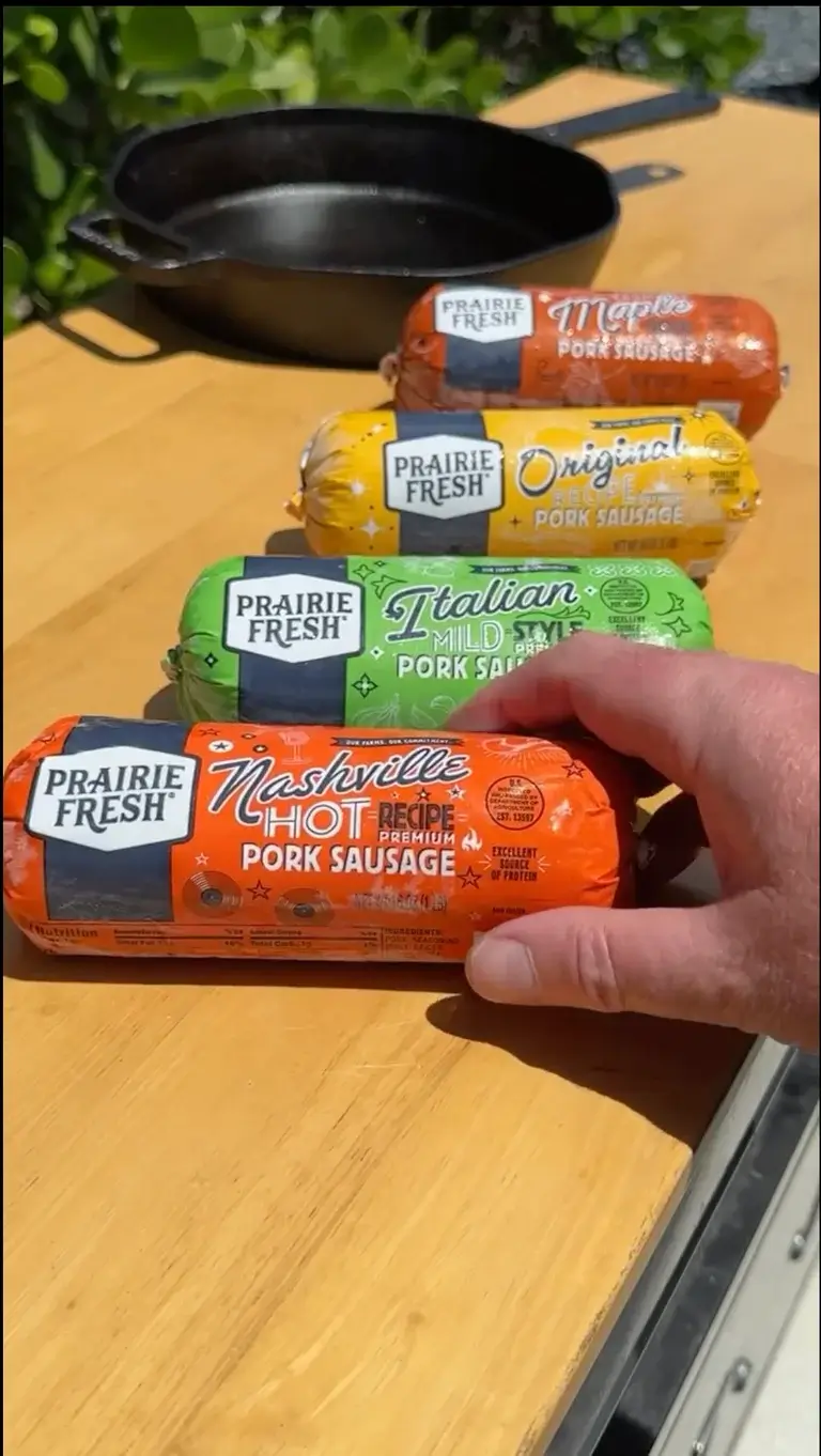 Prairie Fresh® pork sausage varieties including Nashville Hot, Italian, Original and Maple on an outdoor table.