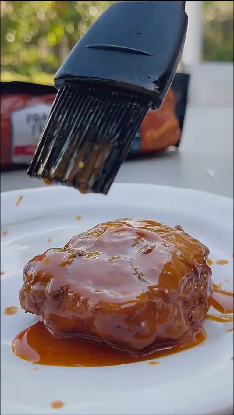 Prairie Fresh® Nashville Hot buttermilk-fried pork loin filet brushed with barbecue sauce on white plate.
